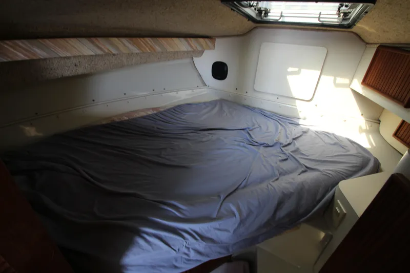 Slide: The Image of 1990 Boston Whaler 31 Sportfisherman cabin interior with bed and natural light. - 13