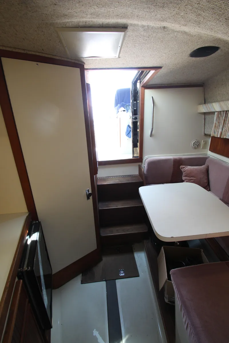 Slide: The Image of 1990 Boston Whaler 31 Sportfisherman cabin interior with seating and table. - 14