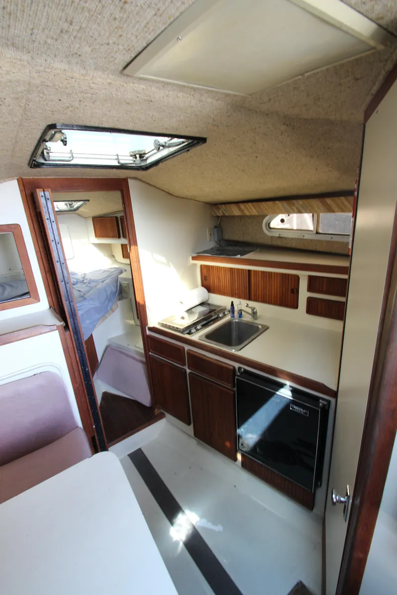 Slide: The Image of 1990 Boston Whaler 31 Sportfisherman interior with kitchenette and sleeping area. - 19