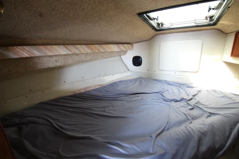 Slide: The Image of 1990 Boston Whaler 31 Sportfisherman cabin interior with bed and overhead hatch. - 21