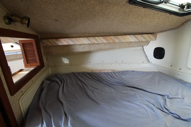 Slide: The Image of 1990 Boston Whaler 31 Sportfisherman cabin interior with bed and window. - 22