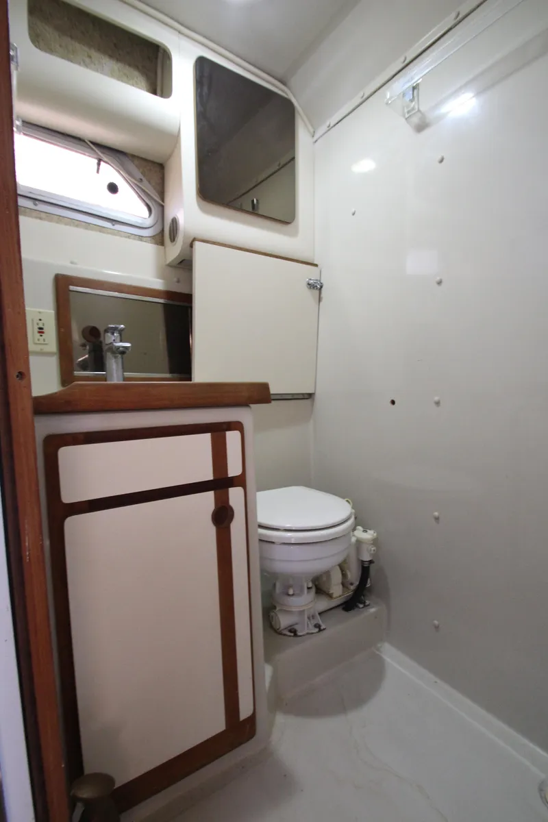 Slide: The Image of 1990 Boston Whaler 31 Sportfisherman bathroom with sink, toilet, and storage cabinets. - 27