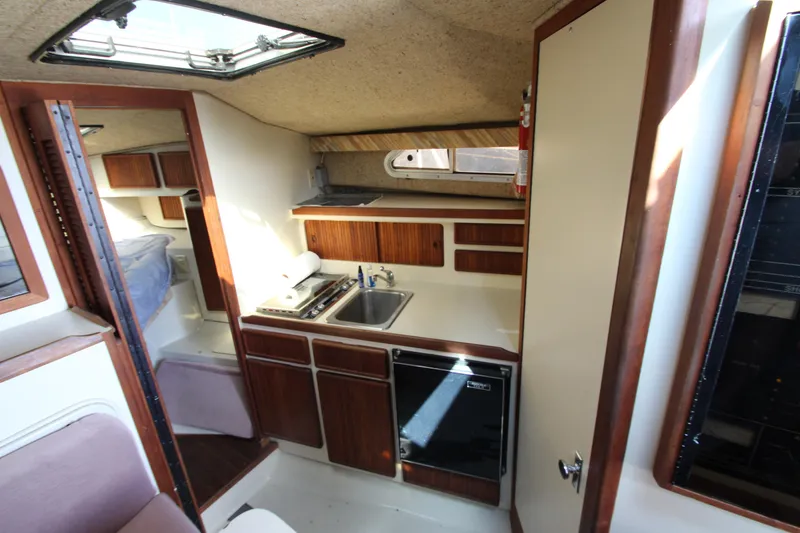 Slide: The Image of Interior of 1990 Boston Whaler 31 Sportfisherman with kitchenette and seating area. - 28
