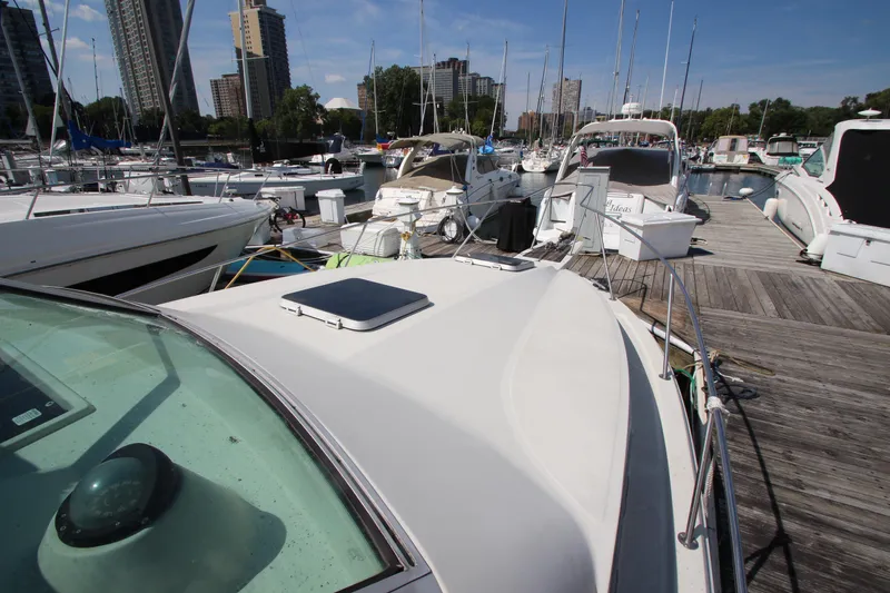 Slide: The Image of 1990 Boston Whaler 31 Sportfisherman docked at a marina with surrounding boats. - 32