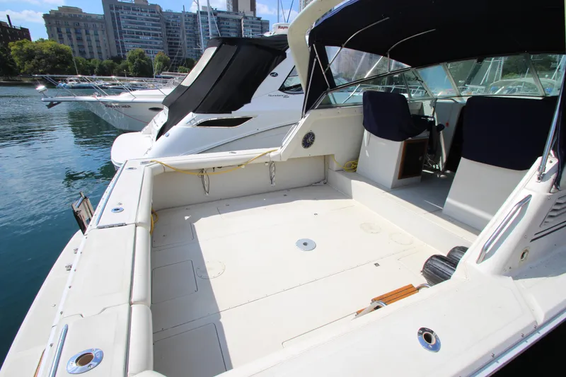 Slide: The Image of 1990 Boston Whaler 31 Sportfisherman boat docked, spacious deck, urban marina backdrop. - 6