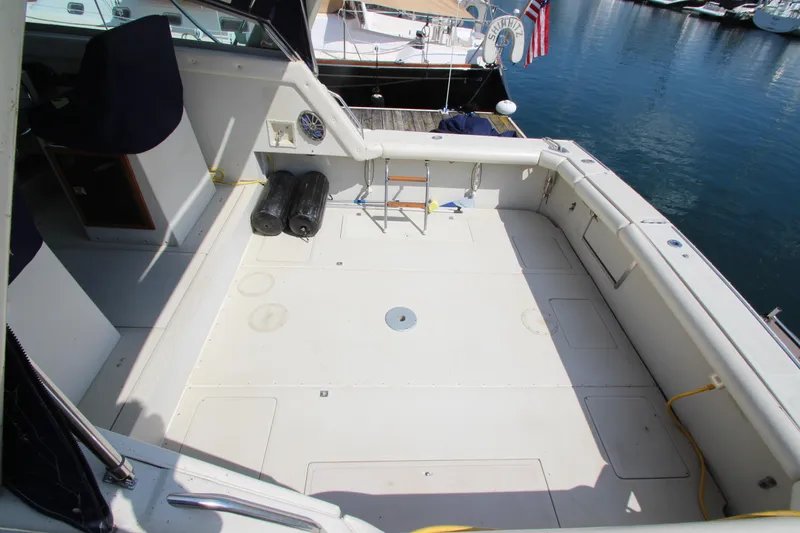 Slide: The Image of 1990 Boston Whaler 31 Sportfisherman boat deck, spacious and clean, docked at marina. - 8