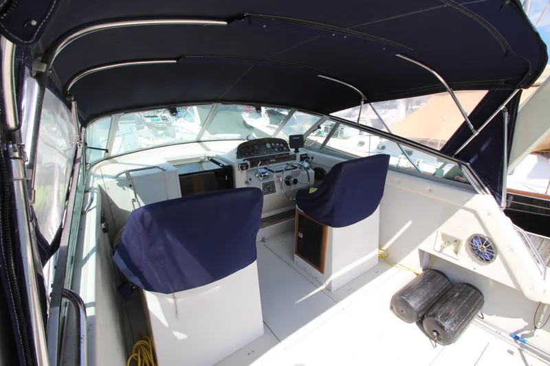 Slide: The Image of 1990 Boston Whaler 31 Sportfisherman cockpit with blue seats and covered helm. - 9