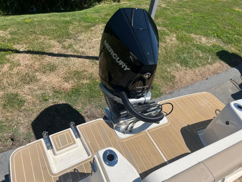 Slide: The Image of 2024 Scout 240 XSF boat with Mercury Verado engine on wooden deck. - 2