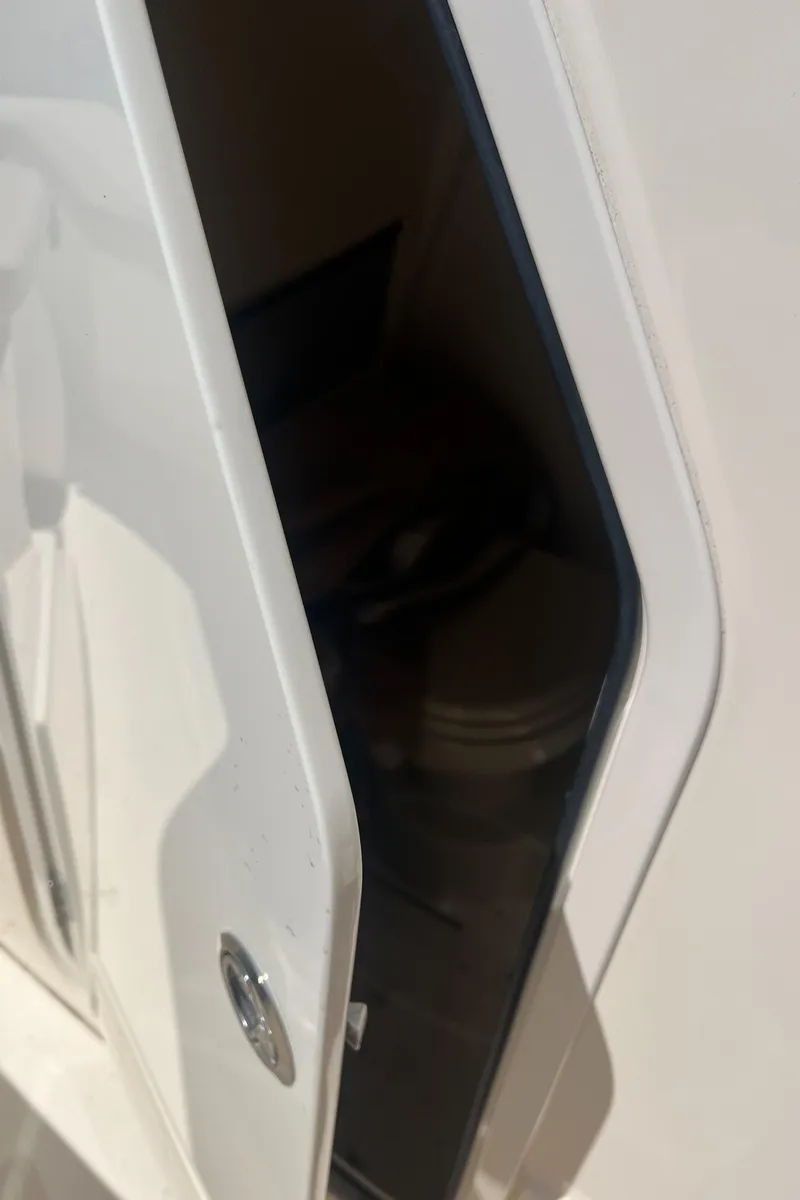 Slide: The Image of 2024 Scout 240 XSF boat storage compartment with open door. - 22