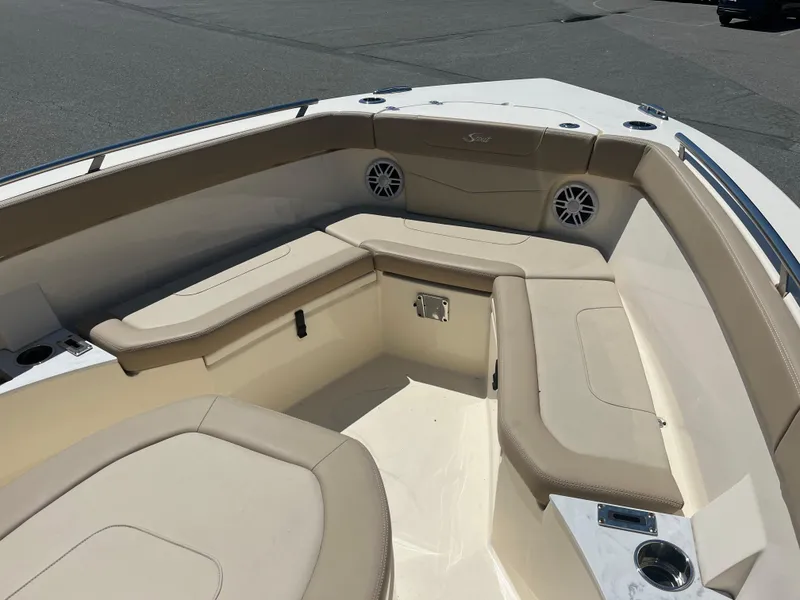 Slide: The Image of 2024 Scout 240 XSF boat interior with beige seating and cup holders. - 3