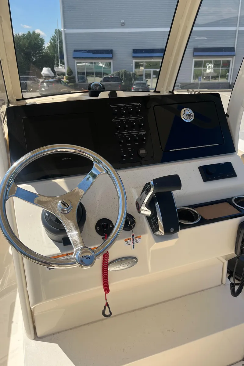 Slide: The Image of 2024 Scout 240 XSF boat dashboard with steering wheel and control panel. - 7