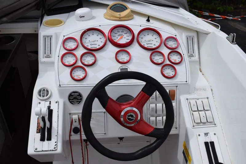 Slide: The Image of Dashboard of a 2000 Baja 40 Outlaw boat with red and white gauges. - 12