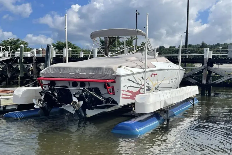Slide: The Image of 2000 Baja 40 Outlaw boat docked, featuring a covered deck and twin engines. - 17