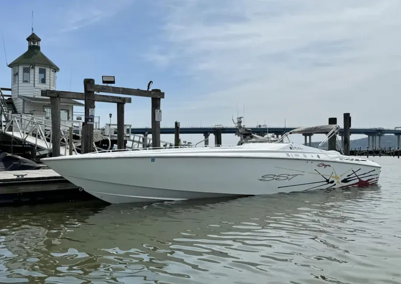Slide: The Image of 2000 Baja 40 Outlaw boat docked at marina, calm water, clear sky. - 2