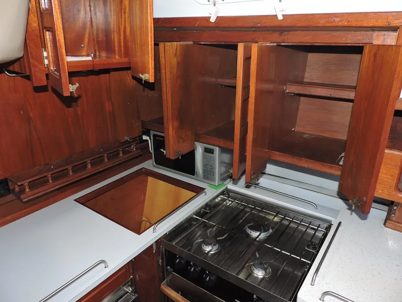 Slide: The Image of 1981 Endeavour 43 yacht kitchen with wooden cabinets, stove, and countertop. - 11