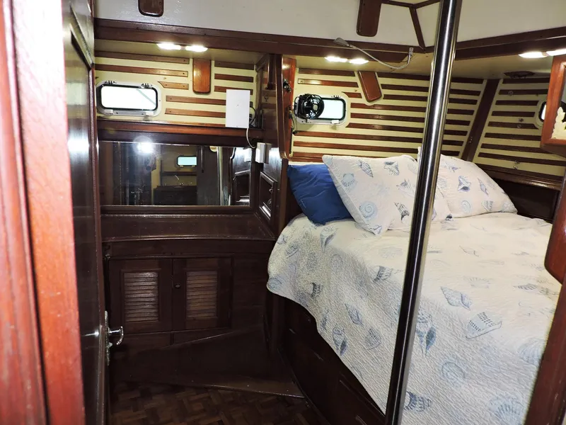 Slide: The Image of Cozy cabin interior of 1981 Endeavour 43 sailboat with wood paneling and comfortable bedding. - 13