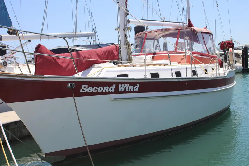 Slide: The Image of 1981 Endeavour 43 sailboat named "Second Wind" docked in a marina. - 2