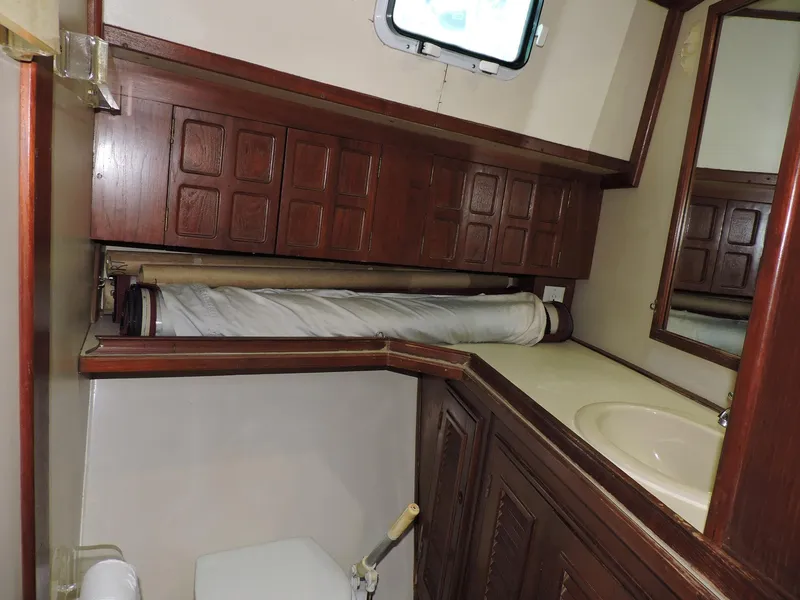 Slide: The Image of 1981 Endeavour 43 yacht bathroom with wooden cabinets and a small window. - 21