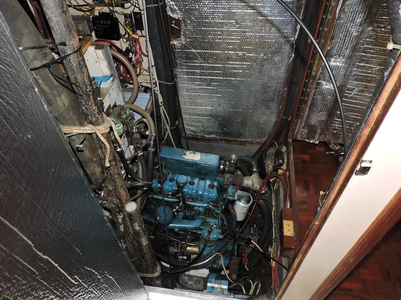 Slide: The Image of Engine room of a 1981 Endeavour 43 sailboat, featuring a blue marine engine. - 27