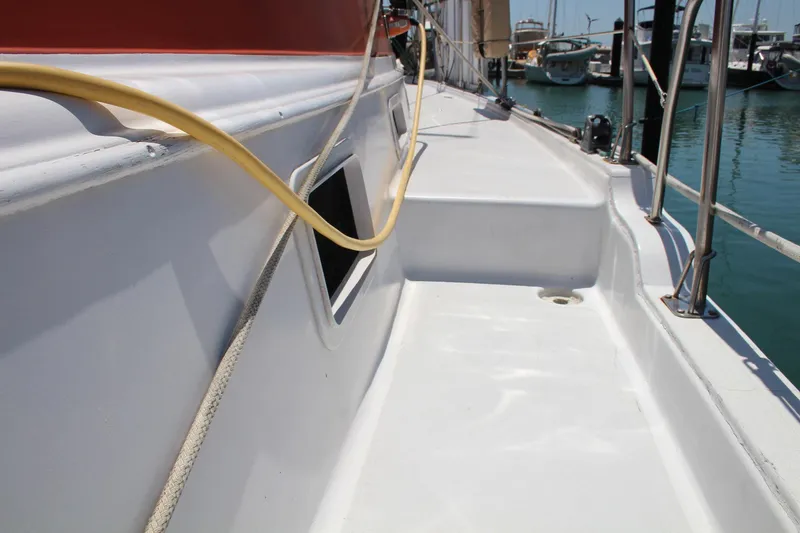Slide: The Image of 1981 Endeavour 43 sailboat deck with marina view, featuring clean white surface and railing. - 28