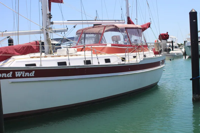 Slide: The Image of 1981 Endeavour 43 sailboat docked in marina, featuring red and white design. - 35