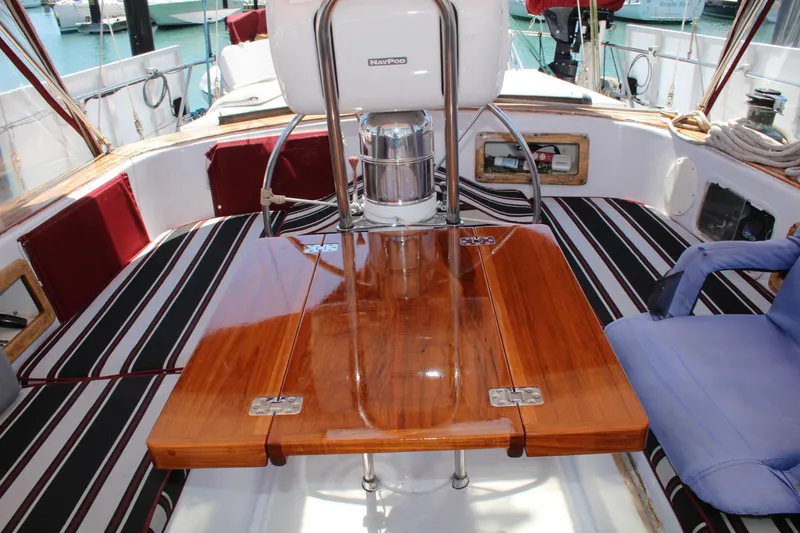 Slide: The Image of Cockpit of 1981 Endeavour 43 sailboat with wooden table and striped seating. - 6