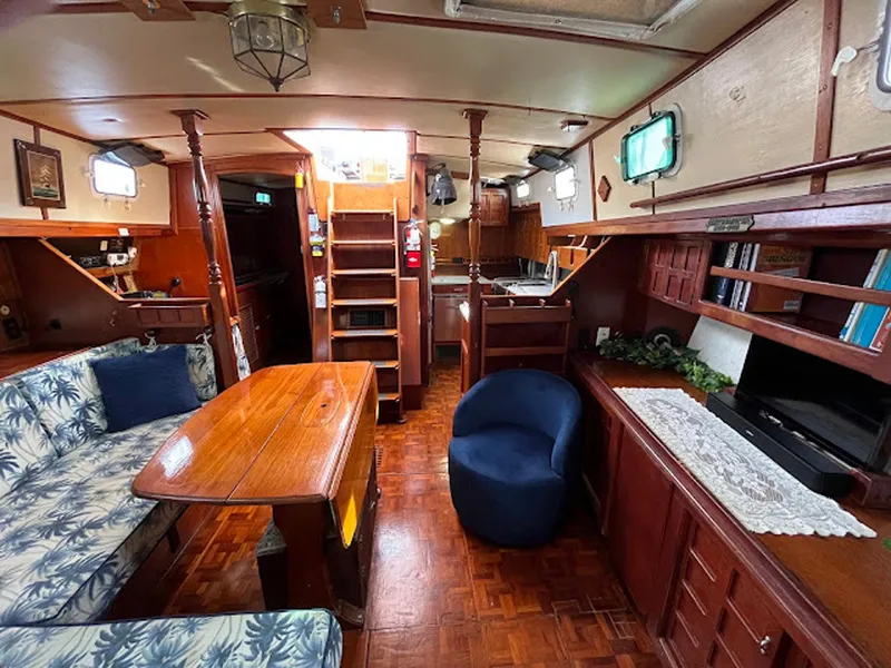 Slide: The Image of Interior of 1981 Endeavour 43 sailboat with wooden furnishings and cozy seating area. - 7