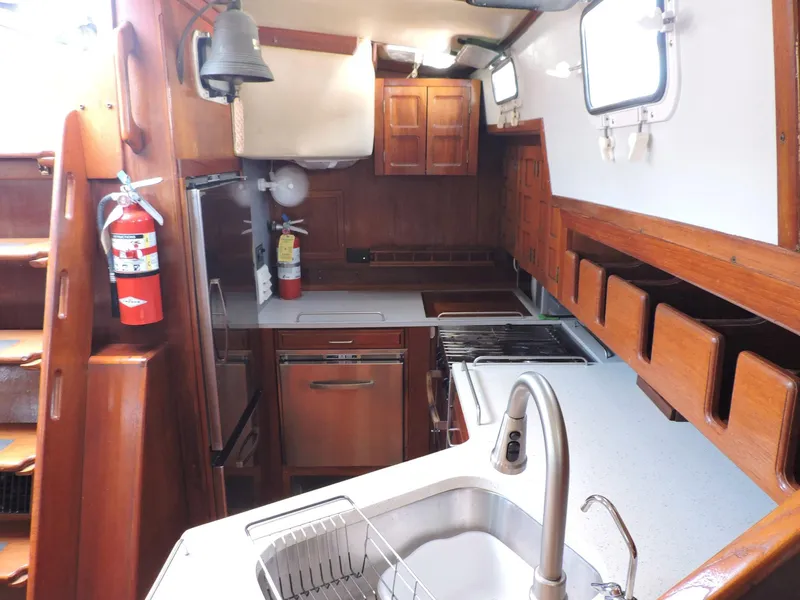 Slide: The Image of Interior of 1981 Endeavour 43 sailboat galley with wooden cabinetry and modern appliances. - 9
