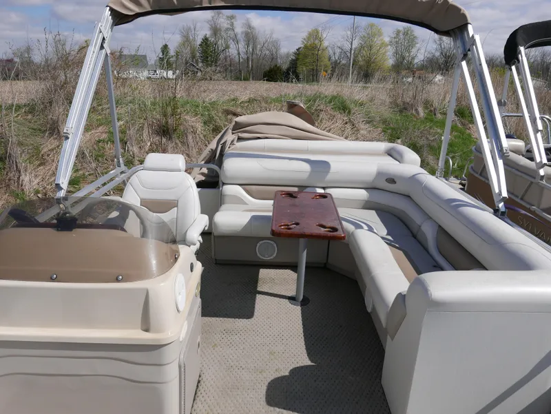 Slide: The Image of 2004 Sylvan Mirage 8522 pontoon boat with beige seating and a wooden table. - 10