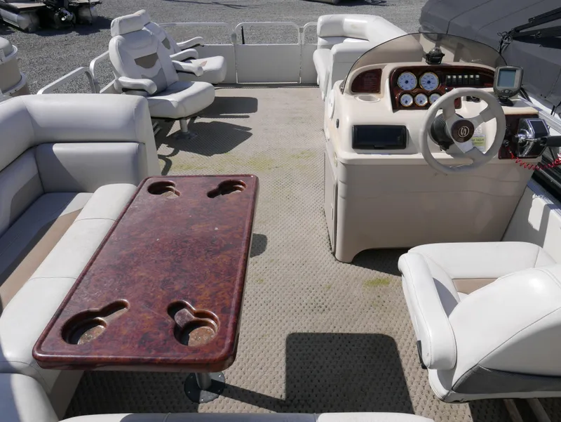 Slide: The Image of 2004 Sylvan Mirage 8522 pontoon boat interior with seating, table, and helm. - 12