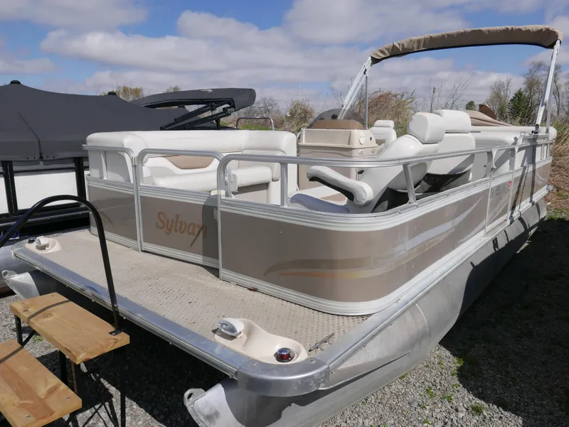 Slide: The Image of 2004 Sylvan Mirage 8522 pontoon boat with beige seating and canopy, parked outdoors. - 5