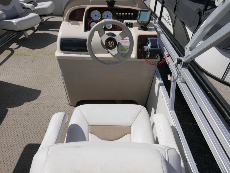 Slide: The Image of 2004 Sylvan Mirage 8522 boat interior with steering console and seating. - 9