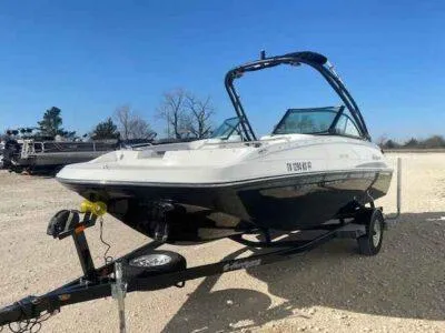 Slide: The Image of 2023 Hurricane SunDeck 187 OB boat on trailer, parked outdoors under clear blue sky. - 2