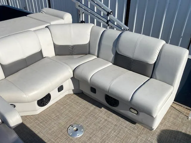 Slide: The Image of 2024 SunCatcher Fusion 322FC boat seating with white and gray upholstery, featuring built-in speakers. - 11