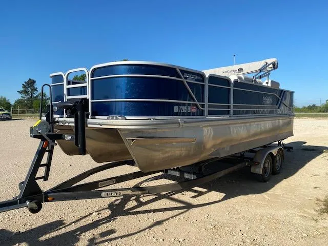 Slide: The Image of 2024 SunCatcher Fusion 322FC pontoon boat on trailer, parked outdoors. - 2