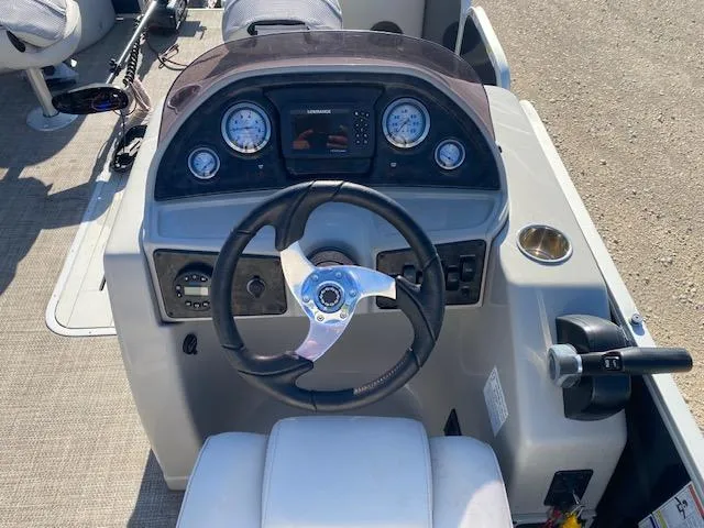 Slide: The Image of 2024 SunCatcher Fusion 322FC boat dashboard with steering wheel and control panel. - 6