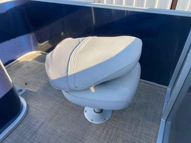 Slide: The Image of 2024 SunCatcher Fusion 322FC boat seat with blue paneling and beige flooring. - 8