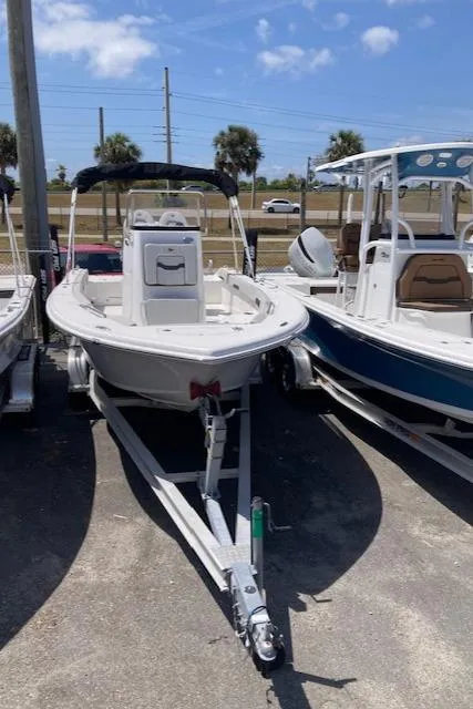 Slide: The Image of 2025 Sea Pro 202 Center Console boat on trailer, parked outdoors under a clear sky. - 11