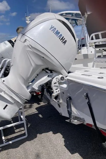 Slide: The Image of 2025 Sea Pro 202 Center Console with Yamaha outboard motor, docked under clear blue sky. - 14