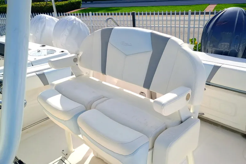 Slide: The Image of 2025 Robalo R230 Center Console boat with white cushioned seating and armrests. - 12