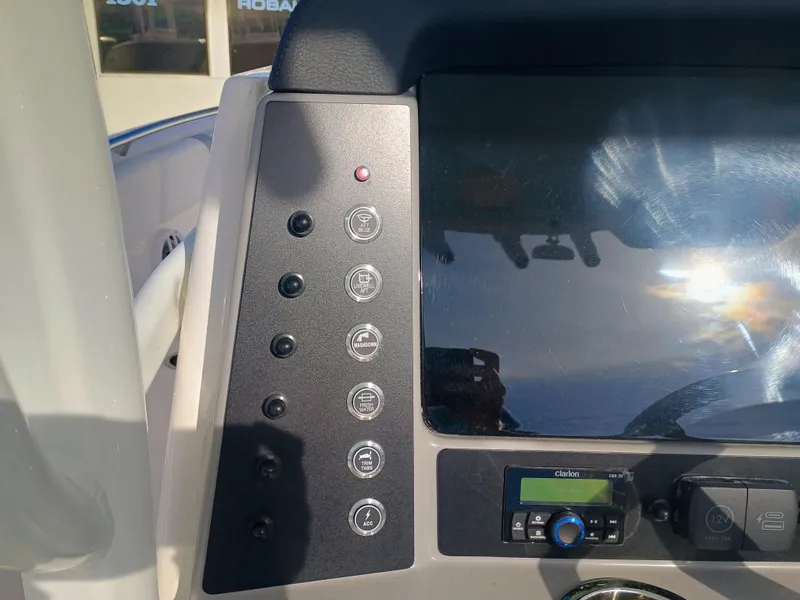 Slide: The Image of Control panel of 2025 Robalo R230 Center Console boat with various switches and display. - 16