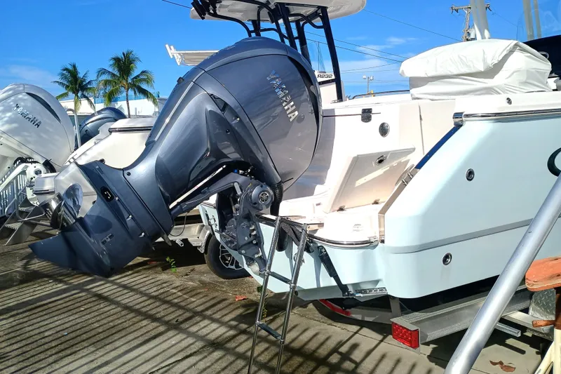 Slide: The Image of 2025 Robalo R230 Center Console boat with Yamaha outboard motor, docked under clear blue sky. - 23