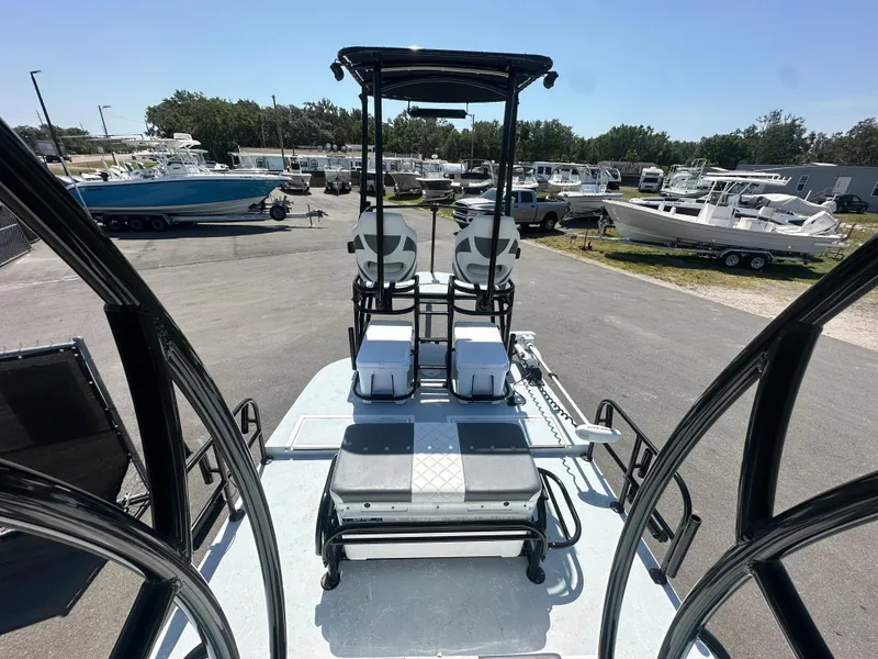 Slide: The Image of 2024 Shallow Master 270 SMC boat with dual seats and elevated helm in a marina setting. - 21