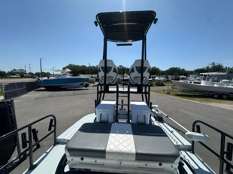 Slide: The Image of 2024 Shallow Master 270 SMC boat with elevated seating and spacious deck in a marina. - 23