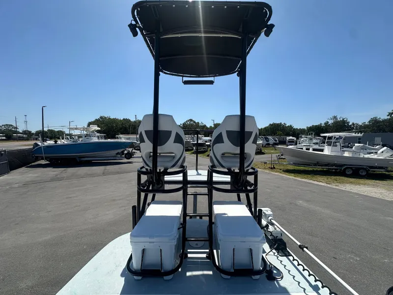 Slide: The Image of 2024 Shallow Master 270 SMC boat with dual seats and canopy, parked in a marina. - 25