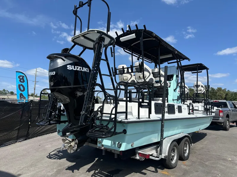 Slide: The Image of 2024 Shallow Master 270 SMC boat with Suzuki engine on trailer, under clear blue sky. - 5