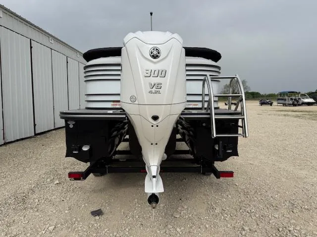 Slide: The Image of 2025 SunCatcher Elite 324 RC boat with powerful 300 V6 engine, parked outdoors. - 4