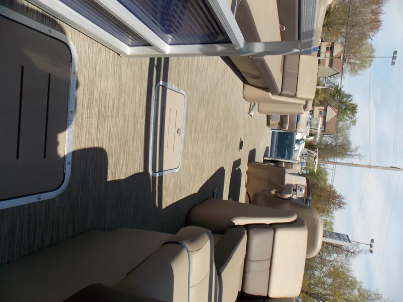 Slide: The Image of 2022 Bennington SX 23 Quad Bench interior with beige seating and spacious layout. - 10