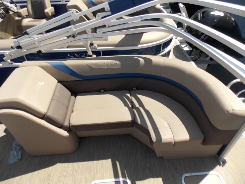 Slide: The Image of 2022 Bennington SX 23 Quad Bench with beige seating and blue accents on a pontoon boat. - 11