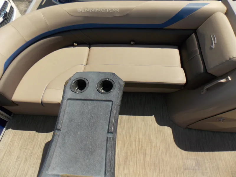 Slide: The Image of 2022 Bennington SX 23 Quad Bench interior with beige seating and cup holders. - 19